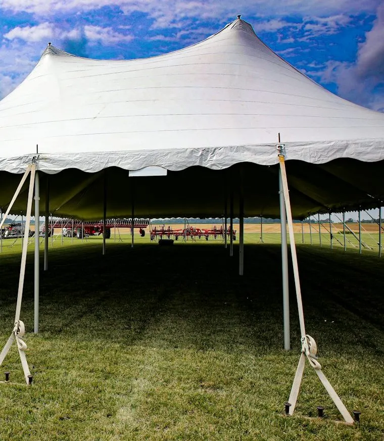 Sample photo: white pole tent with scalloped valance, staked out on a lawn